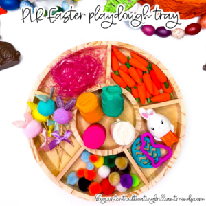 an easter playdough tray with mini carrots, pom poms, and easter grass