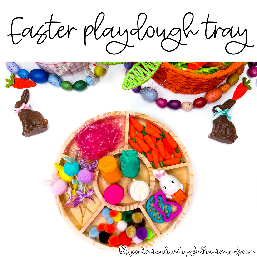 an easter playdough tray with mini carrots, pom poms, and easter grass