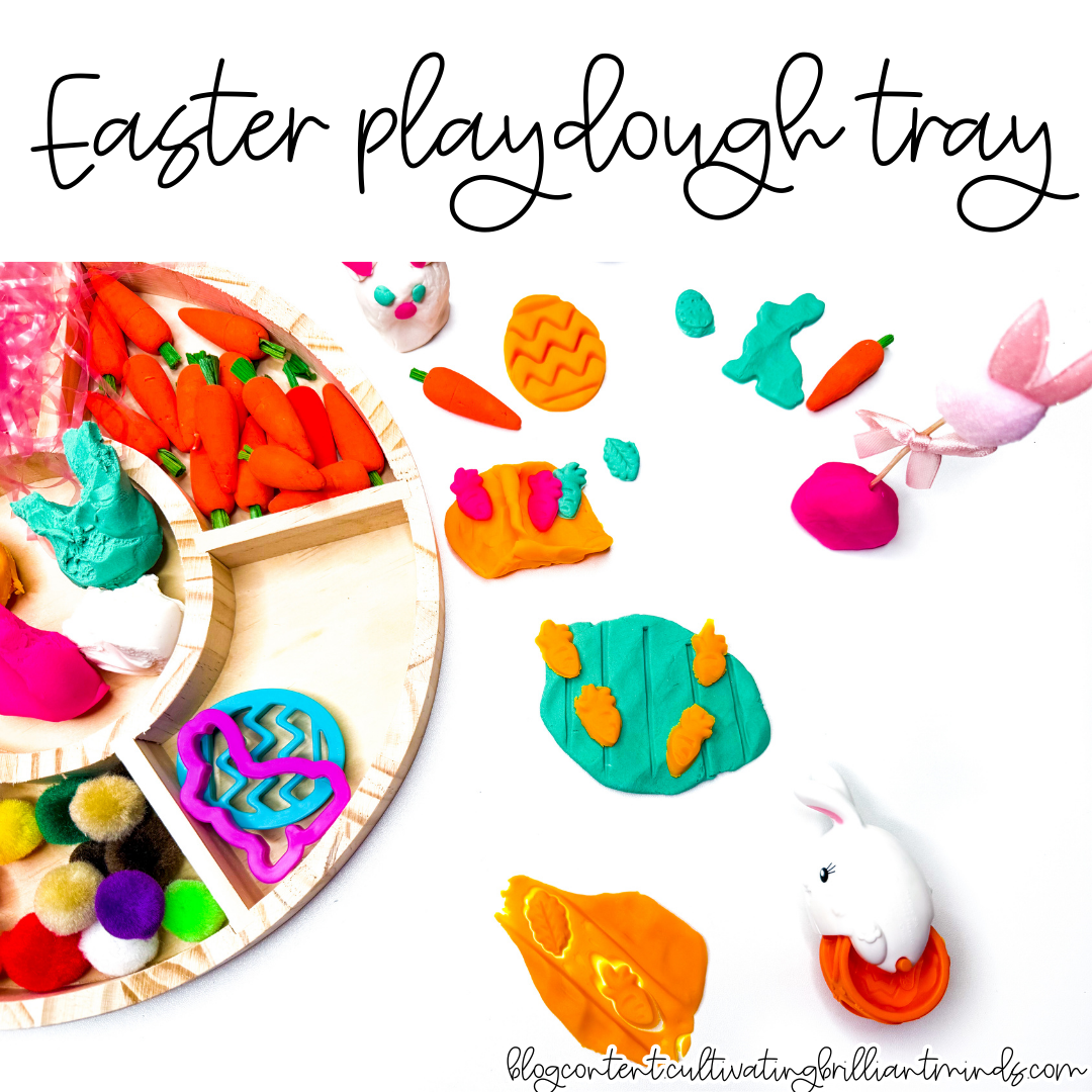 an easter playdough tray with mini carrots, pom poms, and easter grass
