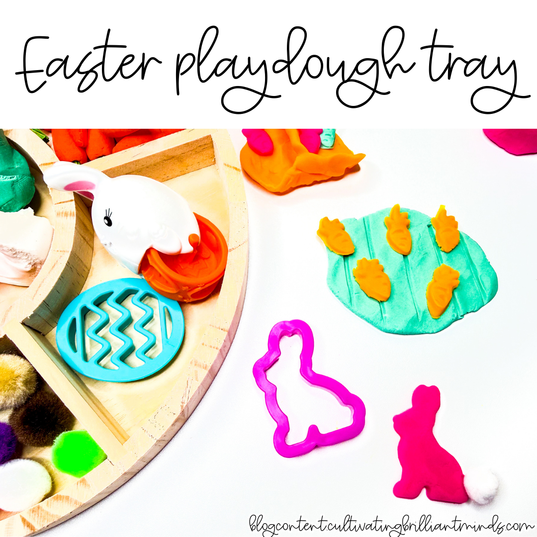 an easter playdough tray with mini carrots, pom poms, and easter grass