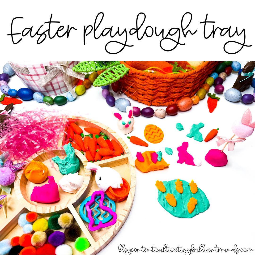 an easter playdough tray with mini carrots, pom poms, and easter grass